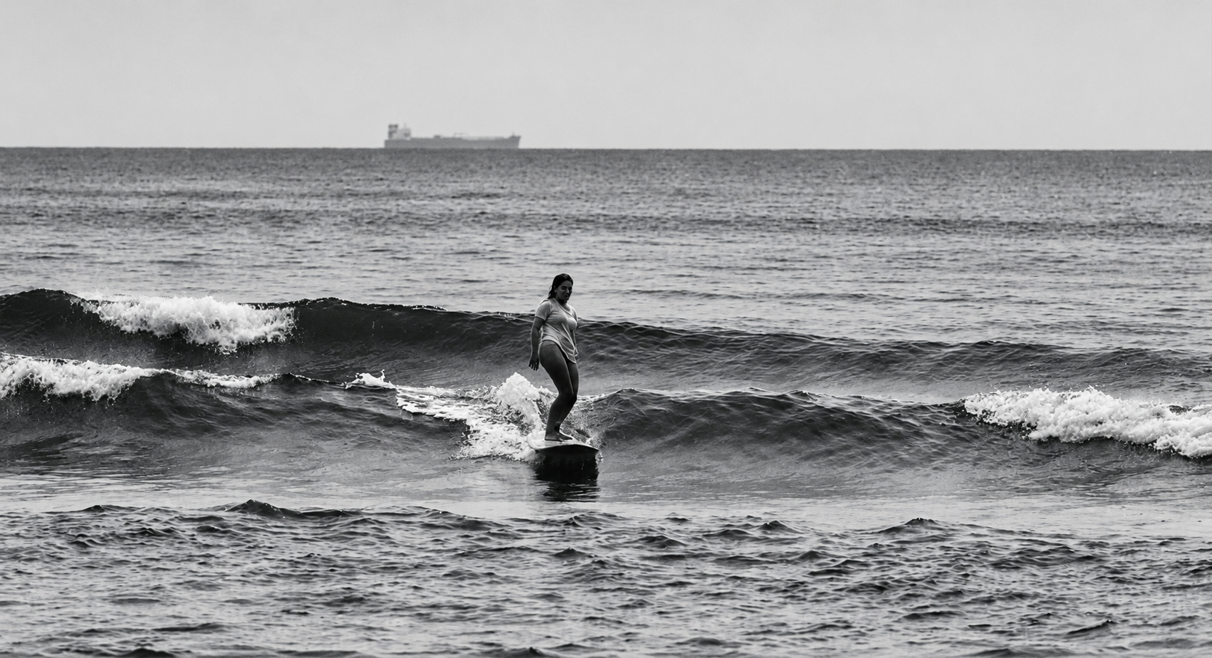 Nicole surfando uma onda, fotografia em preto e branco